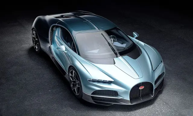 Ein neuer Bugatti in schimmerndem Blau steht auf dunklem Untergrund. Sein Design ist aerodynamisch und luxuriös.