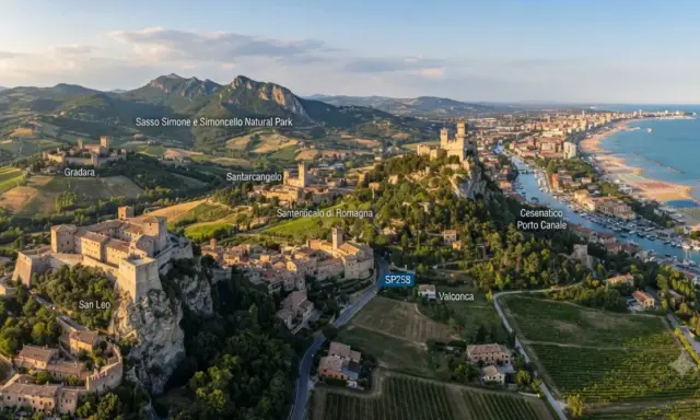 Panoramica aerea di borghi medievali e colline verdi, con il mare Adriatico sullo sfondo. Si vedono San Leo, Gradara, Santarcangelo e Cesenatico, un viaggio tra storia e natura in Romagna.