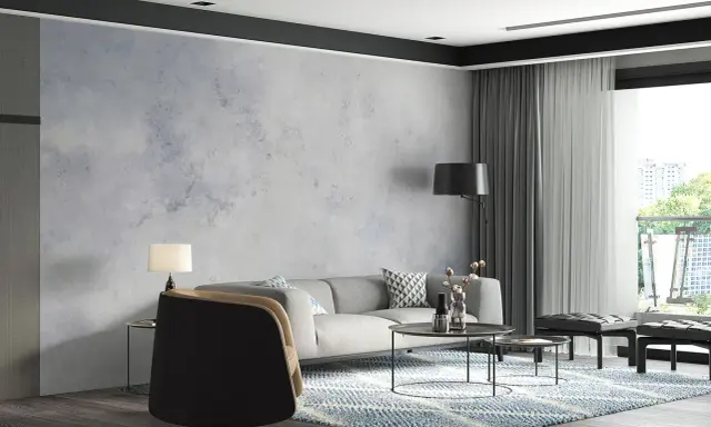 Nowoczesny salon z szarą sofą i fotelem. W tle efektowny **beton na ścianie**, który nadaje wnętrzu industrialnego charakteru.