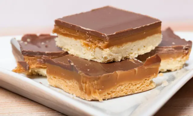 Carrés de shortbread millionnaire au caramel beurre salé, recouverts de chocolat noir. Un délice gourmand.