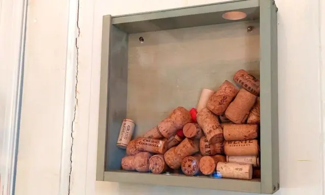 En grå ram fylld med en samling vinkorkar, en tavla som berättar historier från många goda stunder.