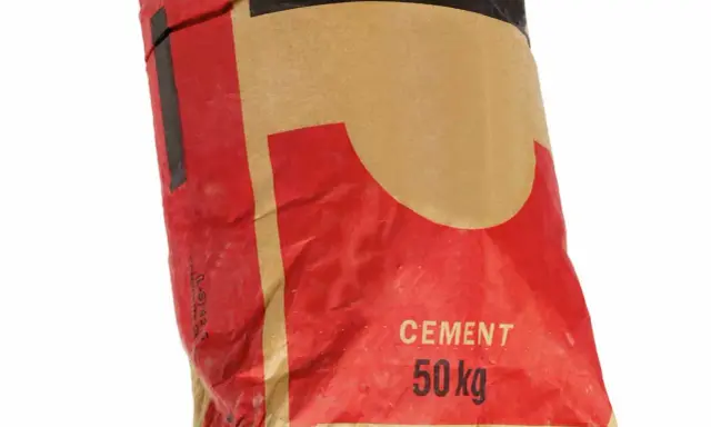 Sac de ciment de 50 kg, idéal pour tout type de ciment. Le sac est rouge et beige avec des inscriptions noires.
