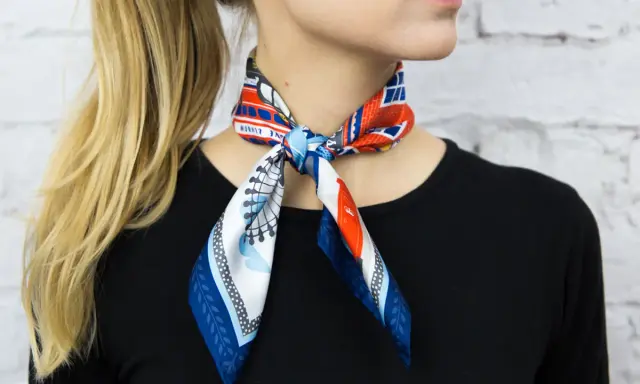 Elegancka gawroszka jak nosić? Wzorzysty apaszek z motywem Londynu zawiązany na szyi, dodaje uroku stylizacji.