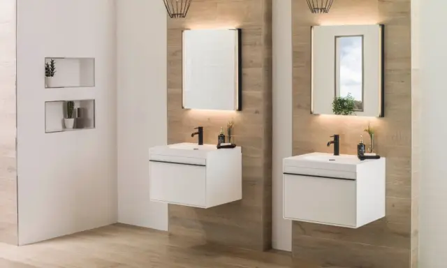Modernos lavabos blancos flotantes con grifería negra, espejos iluminados y detalles en madera. ¡Ideas para baños elegantes!