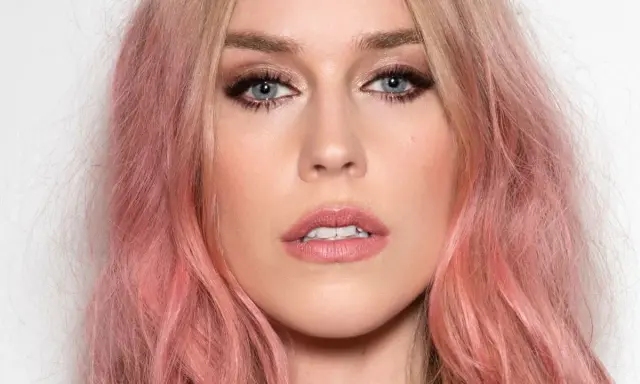 Kobieta z truskawkowym blond kolorem włosów, błękitnymi oczami i delikatnym makijażem.