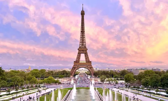 Eiffelturm im Abendrot, ein Muss, wenn man in Paris ist. Brunnen und Menschen beleben die Szenerie.