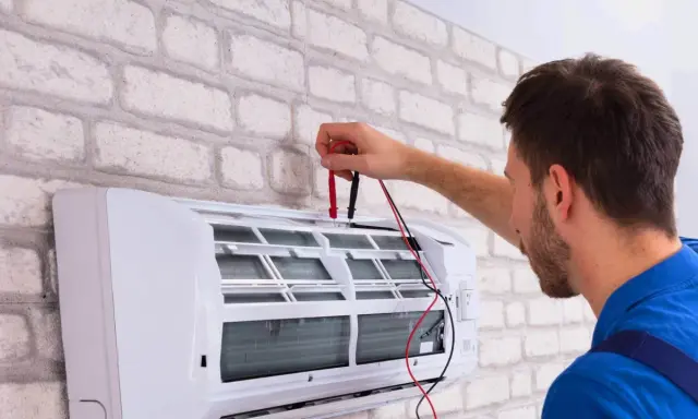 Technik sprawdza klimatyzację, przygotowując ją do dezynfekcji. Czyste powietrze w domu to podstawa.