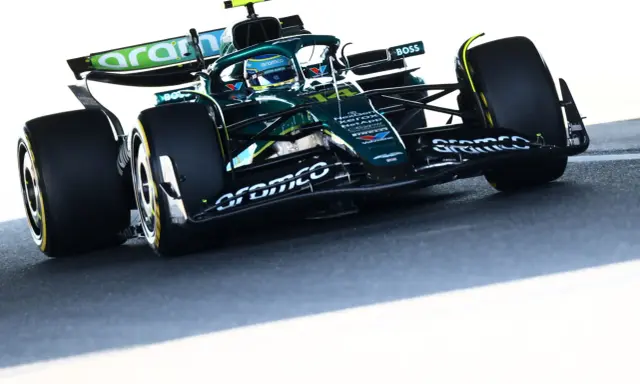 Un coche Aston Martin Honda verde compite en la pista, con el logo de Aramco en el alerón.