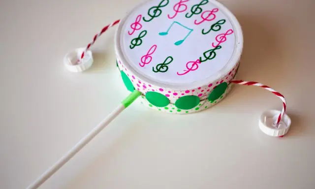 Tambor decorado con notas musicales, hecho con **instrumentos con materiales reciclados**. Ideal para crear música.
