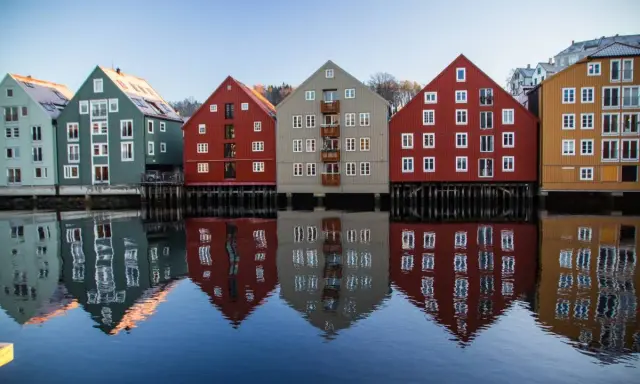 Kolorowe domy nad wodą, odbijające się w spokojnej tafli. Idealne miejsce na pracę z norweskim, podziwiając architekturę.