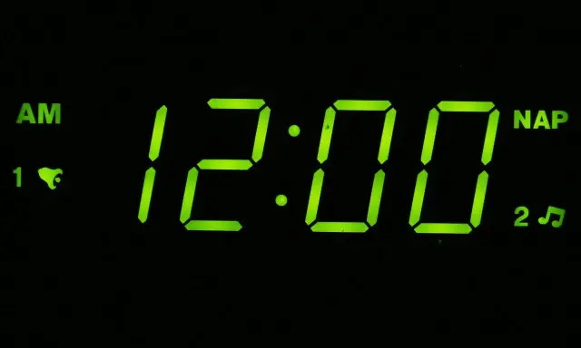 Budzik pokazuje 12:00 AM. To oznacza północ, początek dnia.