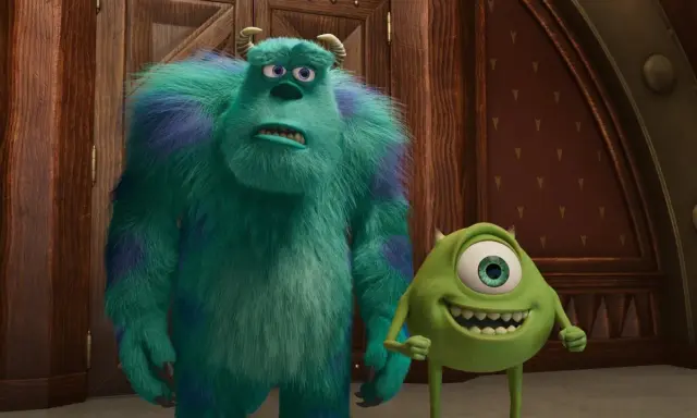 Sully i Mike, bohaterowie bajek z 4 postaciami, stoją obok siebie. Sully wygląda na zmartwionego, a Mike uśmiecha się szeroko.