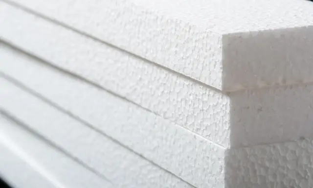 Stapel weißer Styroporplatten, bereit für die Isolierung. Die feine, körnige Textur des Materials ist gut sichtbar.