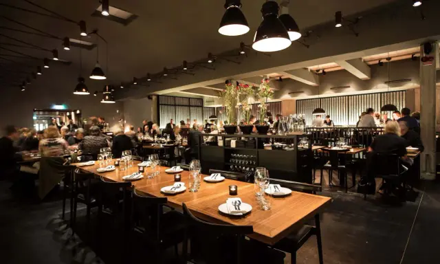 En elegant restaurang i Stockholm med dukade bord och gäster. Kanske en kväll med live musik stockholm?
