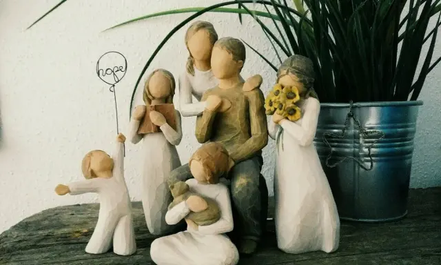Eine griechische Familie aus Figuren: Vater, Mutter, zwei Mädchen, ein Junge und ein Baby. Ein Mädchen hält ein Buch, ein anderes Sonnenblumen.