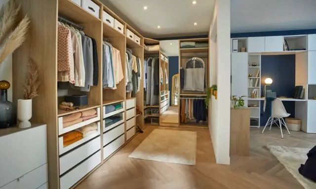 Un dressing aménagé pour un dressing à faire soi même, avec des étagères en bois, des tiroirs et des vêtements bien rangés.
