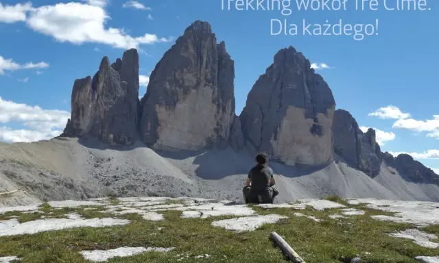 Osoba siedzi na tle majestatycznych Tre Cime, podziwiając widok. Idealne miejsce na trekking!