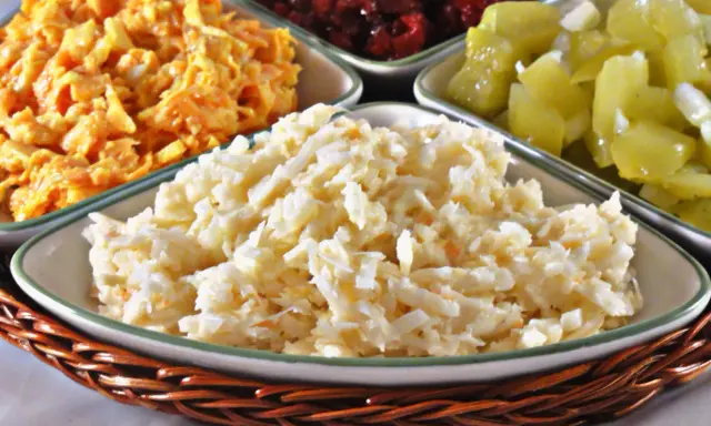 Pyszna surówka z selera, obok innych kolorowych sałatek, czeka na talerzu.