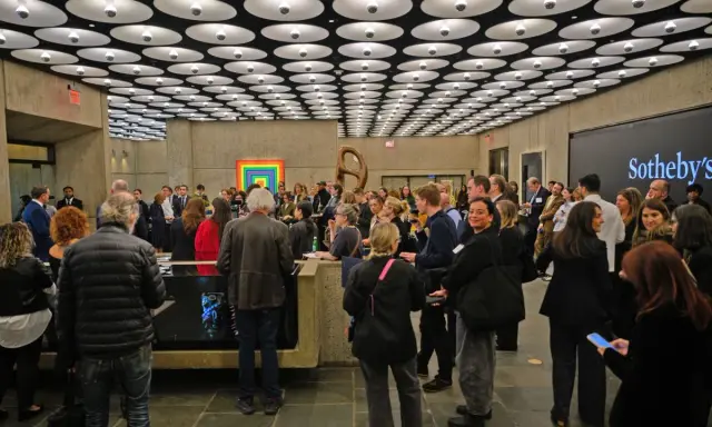A crowd gathers at a Sotheby's event, a vibrant scene in the contemporary art market.