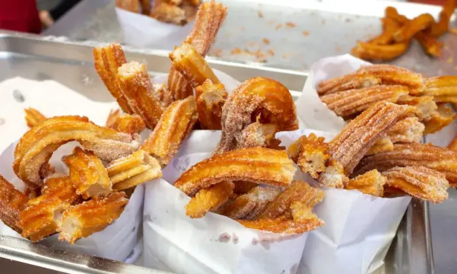 Deliciosos churros recién hechos, cubiertos de azúcar. Una guía visual de como hacer churros perfectos.