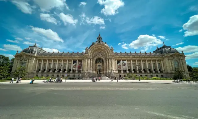 Grand Palais w Paryżu, jeden z najważniejszych zabytków Paryża, z kolumnadą i kopułą pod błękitnym niebem.