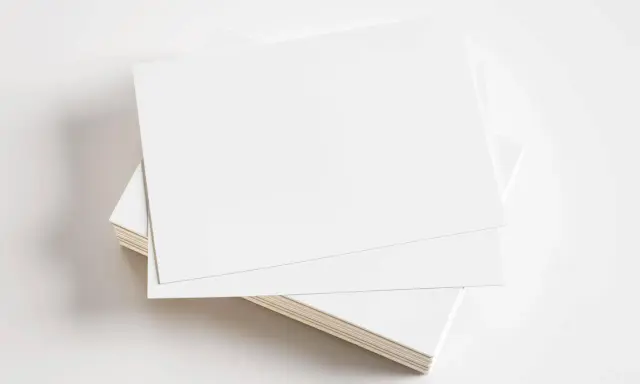 Stos białych kartek, gotowych do zadrukowania. Idealne na wizytówki, zaproszenia lub inne materiały promocyjne z kartonu GC1.