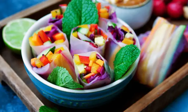Frische Sommerrollen mit buntem Gemüse, Minze und einer Limettenspalte. Ein leichtes Sommerrollen Rezept für heiße Tage.