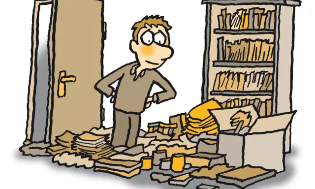 Mann steht in einem Chaos aus Papier und Kartons, fragt sich: warum kann ich keine Ordnung halten? Ein offenes Regal und eine Tür im Hintergrund.