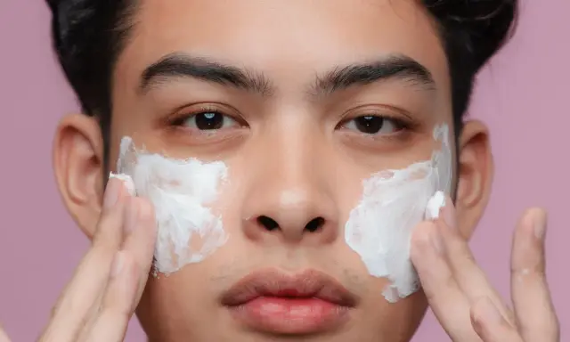 Uomo applica crema sul viso per una pelle perfetta.
