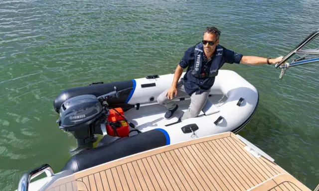 Un homme en gilet de sauvetage dans un semi-rigide, prêt à partir avec le moteur bateau 6cv le plus puissant.