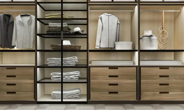 Un moderno armario empotrado con puertas de cristal y madera, organizado con ropa doblada, colgada y accesorios.