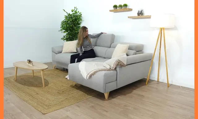 Mujer colocando cojines en chaise longue gris. Un estilo acogedor para tu salón.