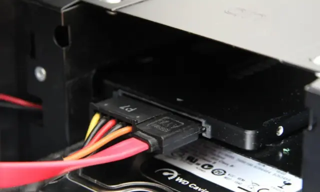 Connexion des câbles SATA pour installer un SSD dans un boîtier d'ordinateur.