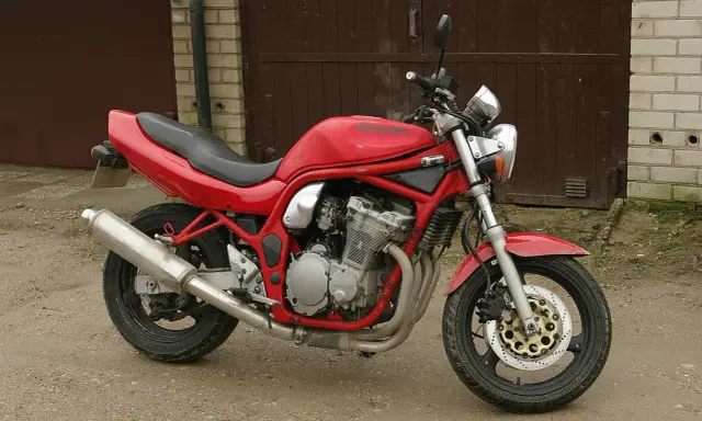 Czerwony Suzuki Bandit 600, gotowy do jazdy, z widocznym silnikiem i wydechem.