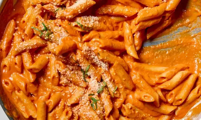 Penne alla vodka w kremowym sosie pomidorowym, posypane parmezanem i bazylią.