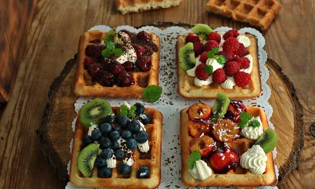 Pyszne gofry belgijskie z owocami: malinami, borówkami, kiwi i śliwkami. Idealne na deser, gdy szukasz inspiracji na gofry belgijskie przepis.