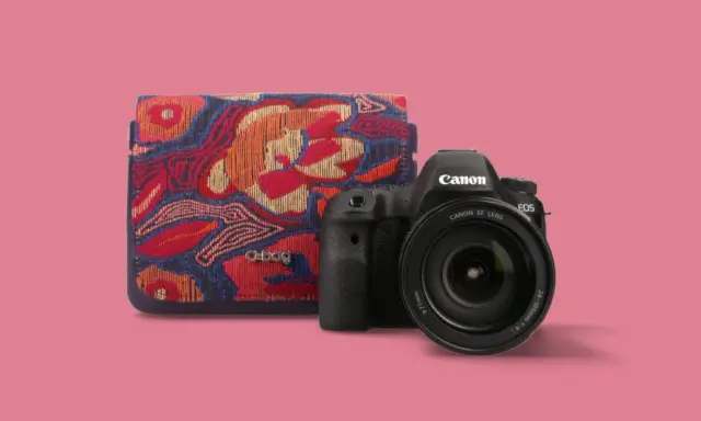 Fotografia produktowa: aparat Canon EOS z obiektywem i etui O bag w kolorowe wzory.