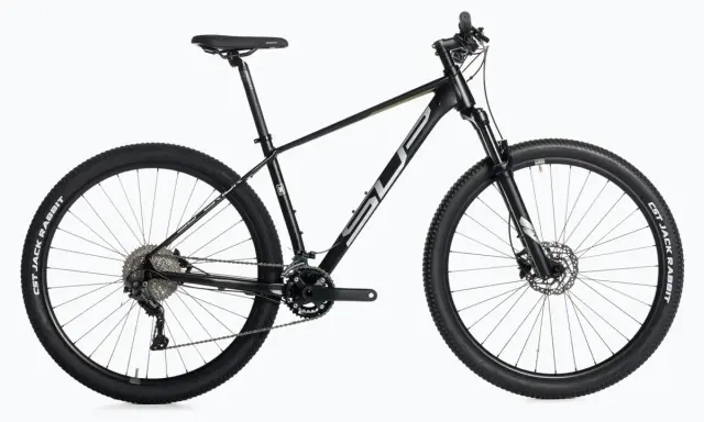 Czarny rower górski, idealny do wyścigów mtb xc. Wyposażony w amortyzator, przerzutki i opony CST Jack Rabbit.