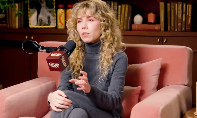 Jennette McCurdy parla con passione, seduta su un divano rosa, con un microfono "Call Her Daddy" davanti.