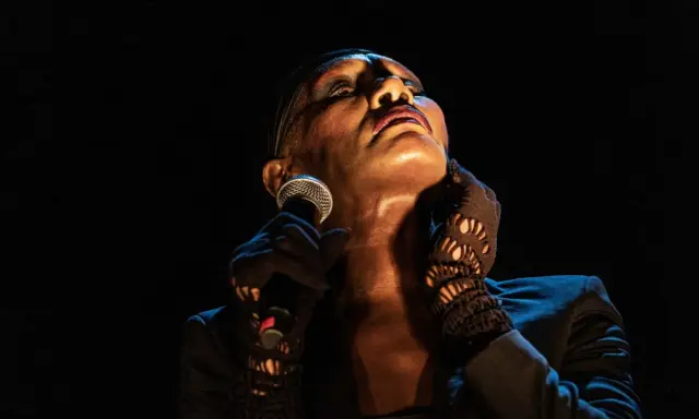 Grace Jones idag, med mikrofonen i handen och blicken uppåt, utstrålar ikonisk scenenergi.