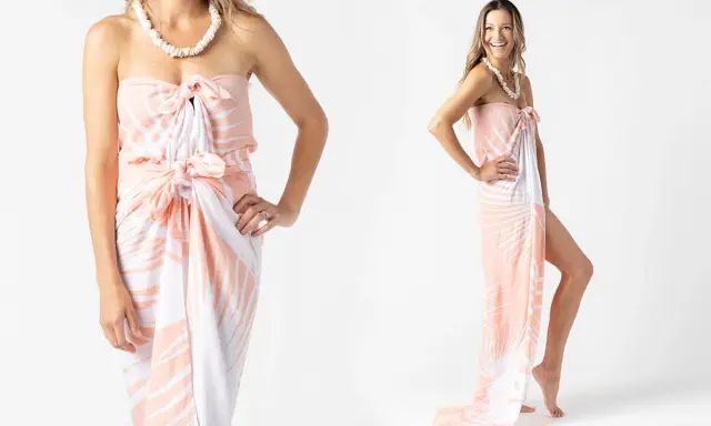 Modella mostra come indossare un pareo con fantasia tropicale, annodato in vita e al seno, con una collana di conchiglie.