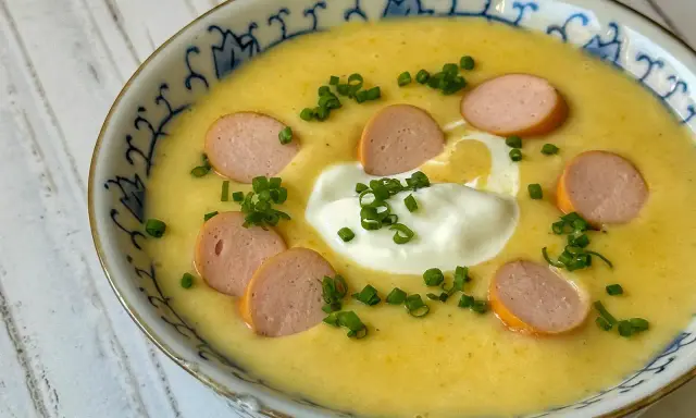 Cremige Kartoffelsuppe mit Würstchenscheiben, einem Klecks Sahne und Schnittlauch. Ein einfaches und leckeres Kartoffelsuppe Rezept für kalte Tage.