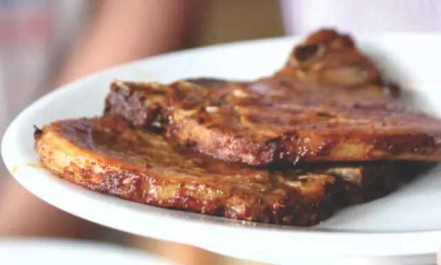 Dos jugosas chuletas de cerdo a la parrilla, doradas y listas para disfrutar.