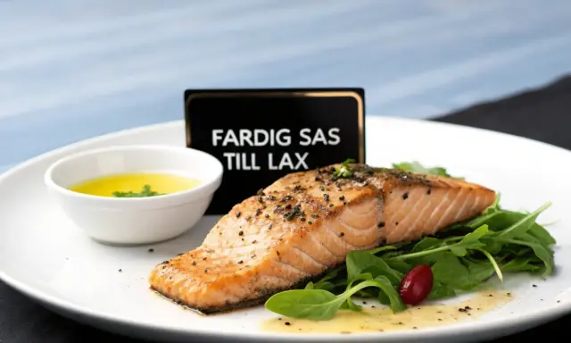 En perfekt tillagad laxfilé serveras med en skål med gul sås till lax, gröna blad och en röd bär.