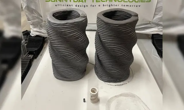Dos jarrones retorcidos creados mediante impresión 3D hormigón. Se aprecian las capas de material.
