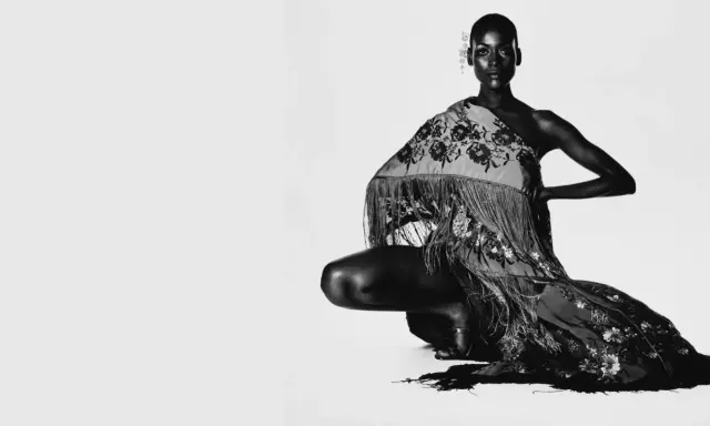 Irving Penn captura a una modelo agachada con un chal bordado y flecos.