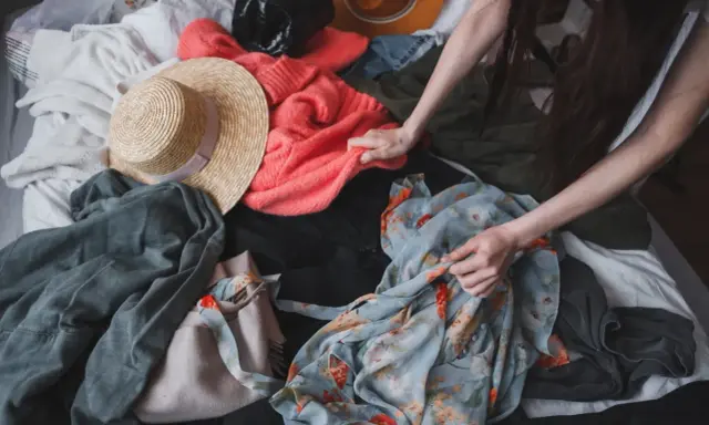 Przesądy związane z rzeczami po zmarłych, jak buty, mogą budzić niepokój. Na zdjęciu widać stos ubrań, wśród nich kapelusze i swetry.