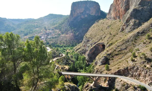 Un puente cruza un cañón con un pueblo en la ladera. El **mirador del infierno** ofrece vistas espectaculares de la garganta y las montañas.