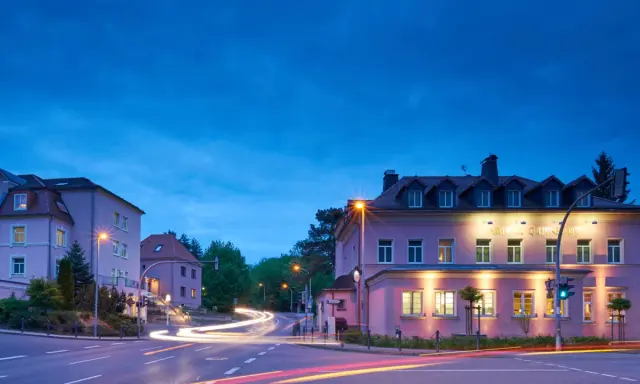 Parkhotel Güldene Berge in Harz bei Nacht, mit Lichtern und Spuren von Autos.