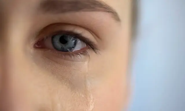 Zbliżenie na niebieskie oko, z którego spływa łza. Scena jak z filmu łzowego, pełna emocji.